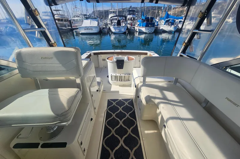 Slide: The Image of 2001 Pursuit 3000 Express boat interior with seating, docked at marina. - 19