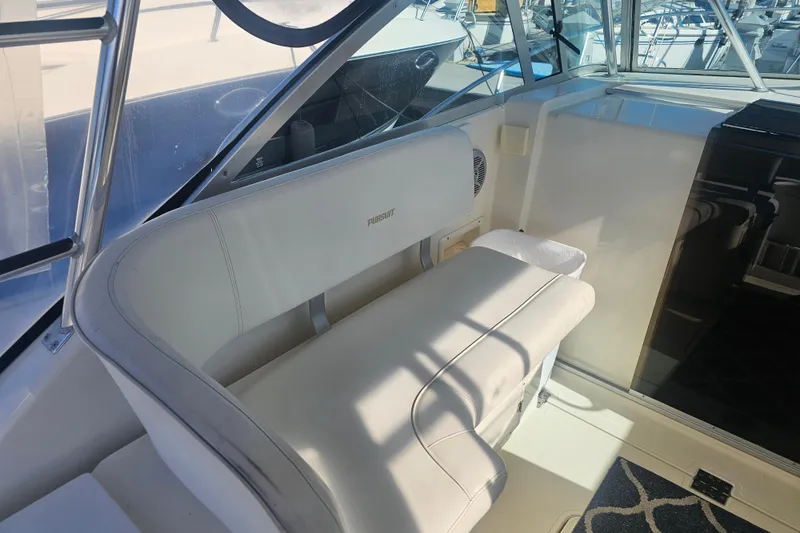 Slide: The Image of 2001 Pursuit 3000 Express boat interior with white seating and helm area. - 20