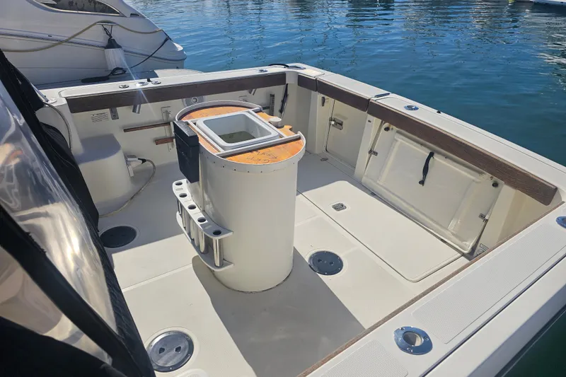 Slide: The Image of 2001 Pursuit 3000 Express boat deck with fishing rod holders and storage compartments. - 3