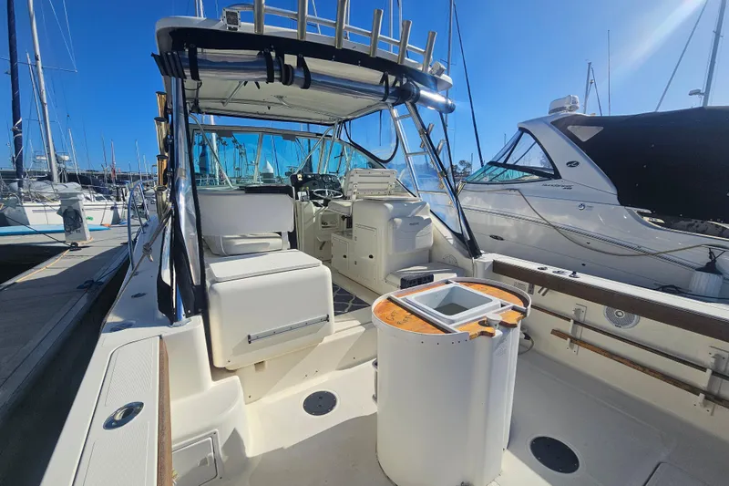 Slide: The Image of 2001 Pursuit 3000 Express boat docked at marina, featuring spacious cockpit and helm. - 31