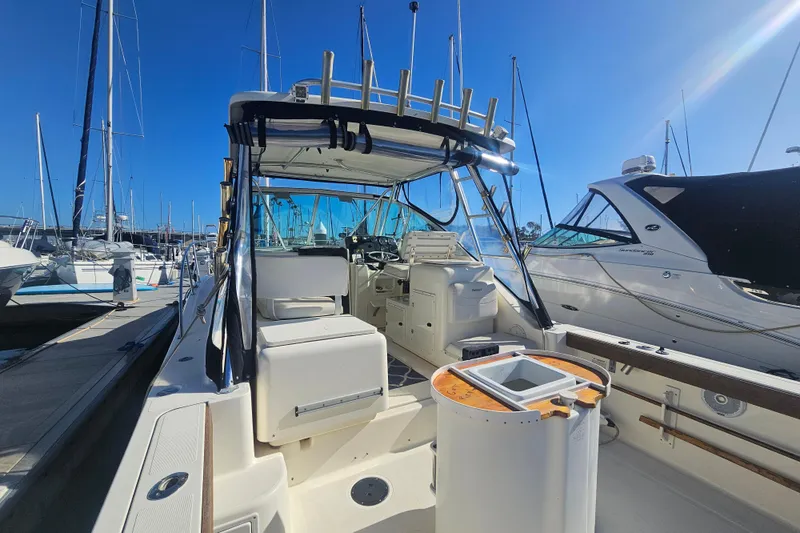 Slide: The Image of 2001 Pursuit 3000 Express boat docked at marina under clear blue sky. - 32