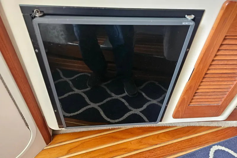 Slide: The Image of 2001 Pursuit 3000 Express interior with Norcold fridge and wooden flooring. - 37