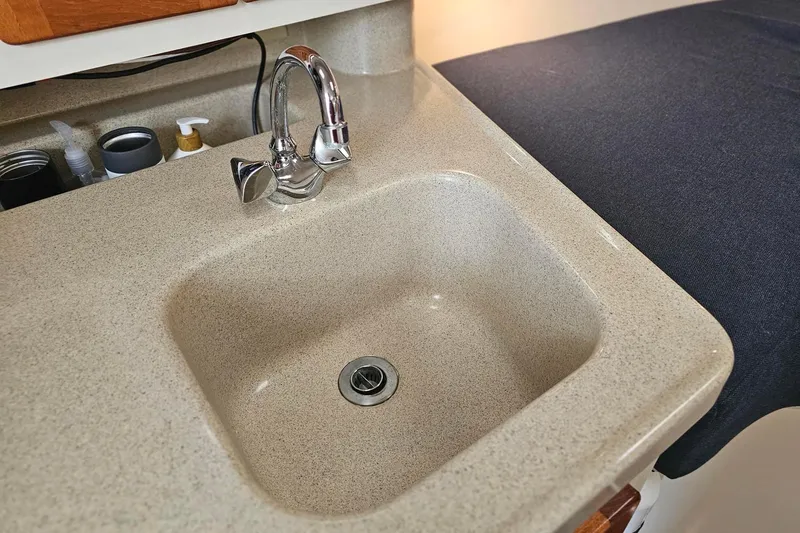 Slide: The Image of 2001 Pursuit 3000 Express boat interior sink with chrome faucet and countertop. - 38