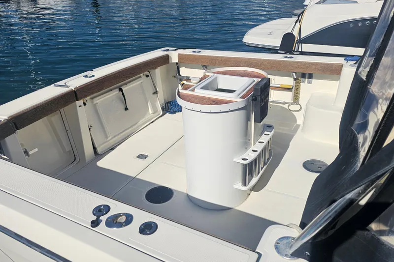 Slide: The Image of 2001 Pursuit 3000 Express boat interior with fishing rod holders and clean deck. - 4