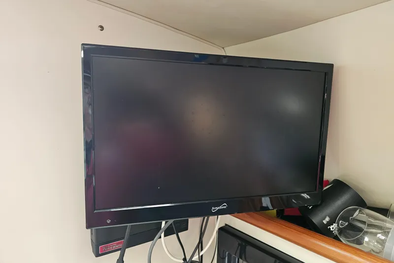 Slide: The Image of Wall-mounted TV inside 2001 Pursuit 3000 Express boat cabin. - 40