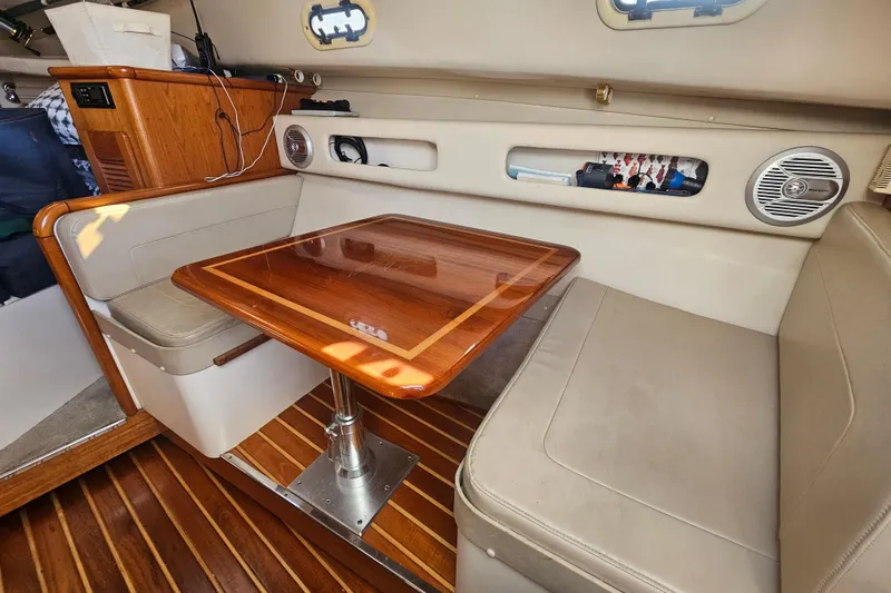 Slide: The Image of 2001 Pursuit 3000 Express cabin with wooden table and cushioned seating. - 44