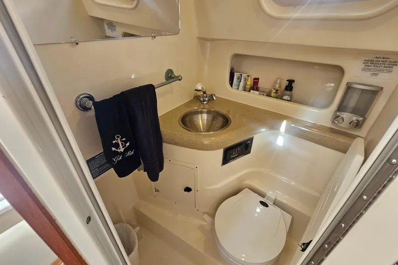 Slide: The Image of 2001 Pursuit 3000 Express boat bathroom with sink, toilet, and toiletries. - 45