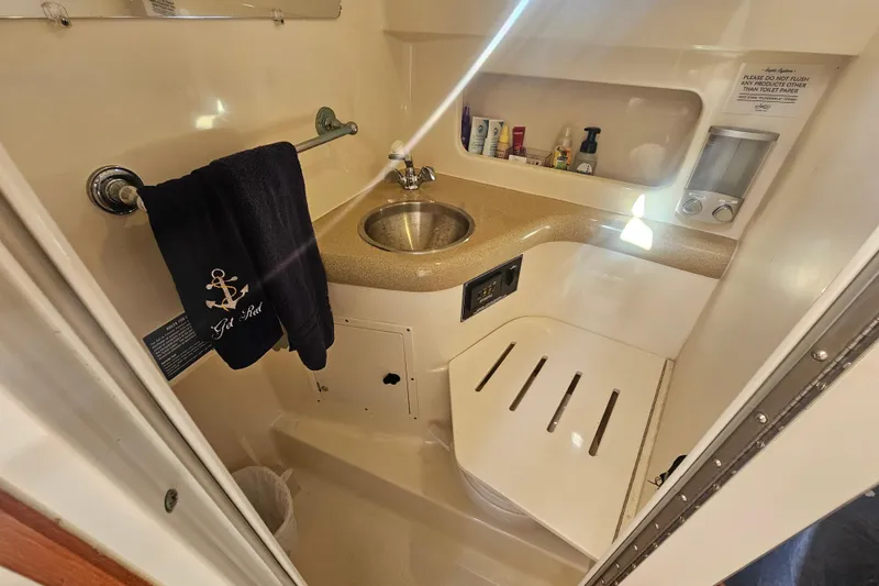 Slide: The Image of 2001 Pursuit 3000 Express boat bathroom with sink, towel, and toiletries. - 46