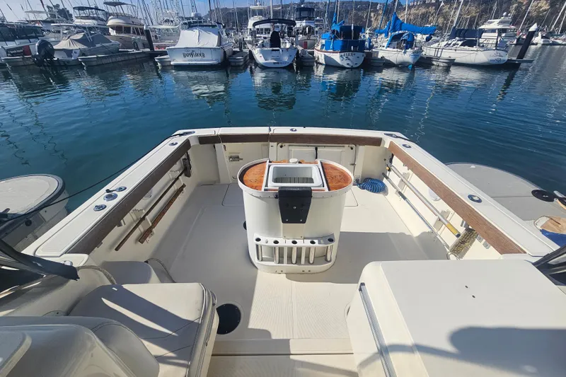 Slide: The Image of 2001 Pursuit 3000 Express boat interior at marina, showcasing spacious deck and seating. - 8