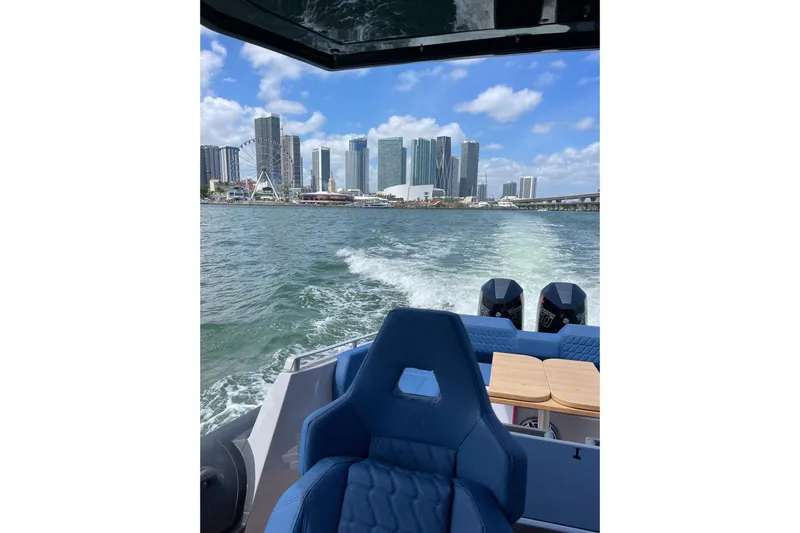 Slide: The Image of 2024 Skipper 42 boat cruising with city skyline in the background. - 12