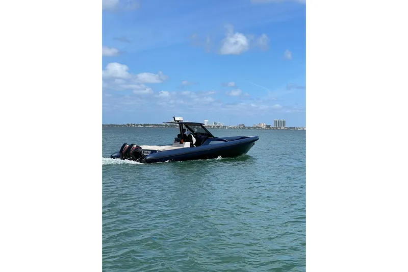 Slide: The Image of 2024 Skipper 42 boat cruising on a sunny day with city skyline in background. - 13