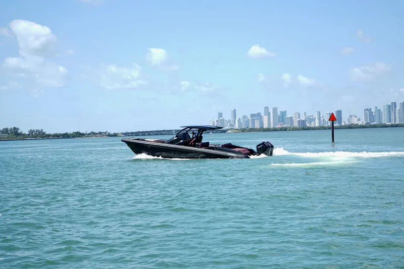 Slide: The Image of 2024 Skipper 42 boat cruising on blue water with city skyline in background. - 28