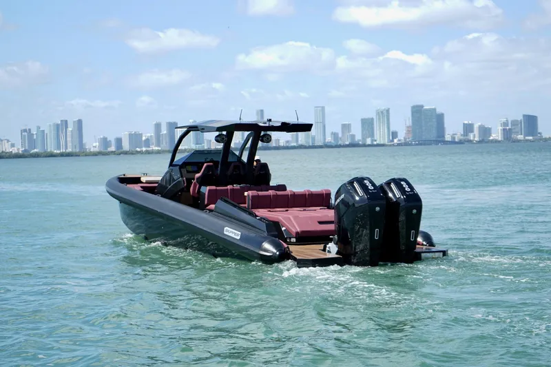 Slide: The Image of 2024 Skipper 42 boat cruising near city skyline, featuring dual outboard engines. - 30