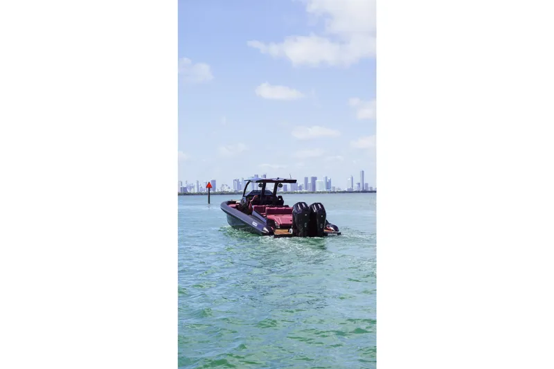 Slide: The Image of 2024 Skipper 42 boat cruising on open water with city skyline in background. - 45