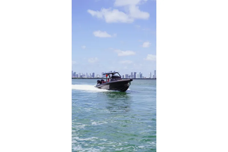 Slide: The Image of 2024 Skipper 42 boat cruising on water with city skyline in background. - 7