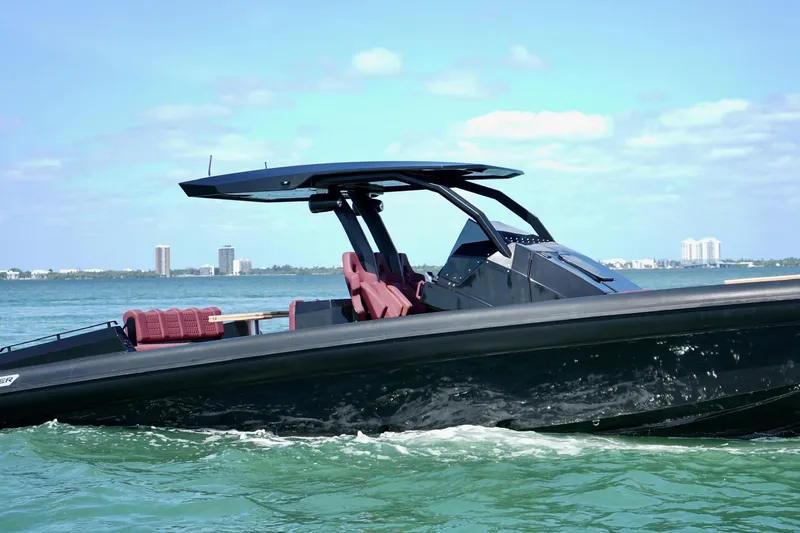 Slide: The Image of 2024 Skipper 42 boat cruising on clear blue water with city skyline in background. - 8