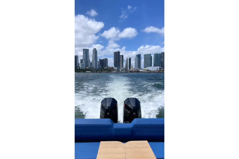 Slide: The Image of Skipper 42 boat cruising with city skyline view, 2024 model. - 9