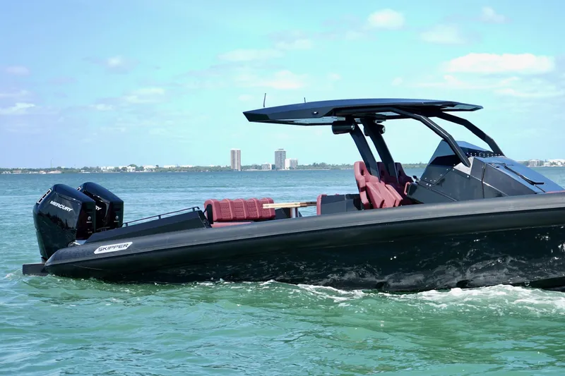 Slide: The Image of 2024 Skipper 42 boat cruising on clear blue water with city skyline in background. - 18