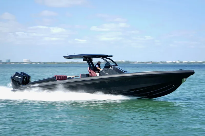 Slide: The Image of 2024 Skipper 42 boat cruising on open water, sleek black design, sunny day. - 38