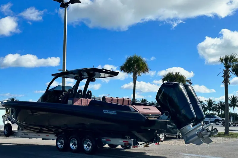 Slide: The Image of 2024 Skipper 42 boat on trailer under blue sky with palm trees. - 46