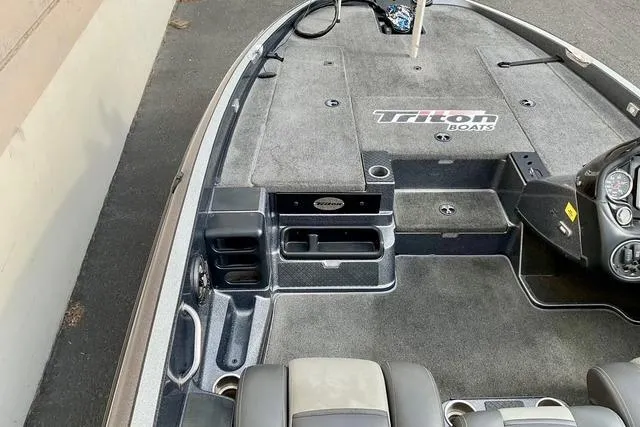 Slide: The Image of 2013 Triton 18XS boat interior with carpeted deck and storage compartments. - 14
