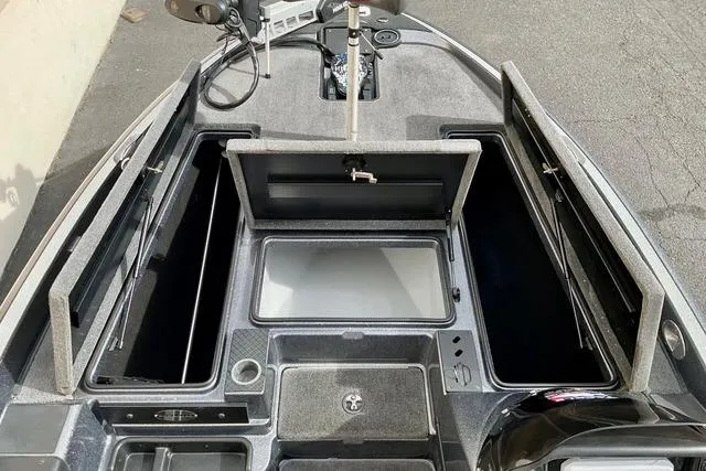 Slide: The Image of 2013 Triton 18XS boat interior with open storage compartments and fishing equipment. - 18