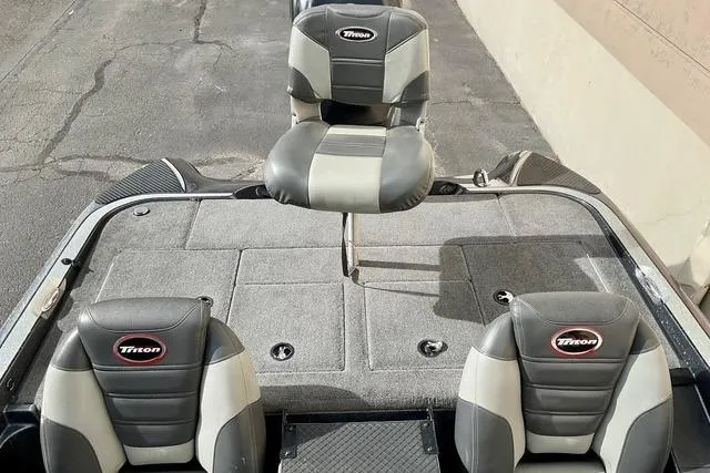 Slide: The Image of 2013 Triton 18XS boat interior with three cushioned seats and carpeted deck. - 21