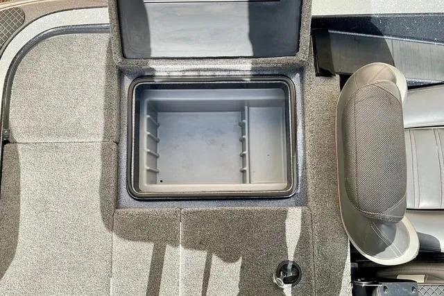 Slide: The Image of Open storage compartment in 2013 Triton 18XS boat, featuring gray interior and seating. - 24