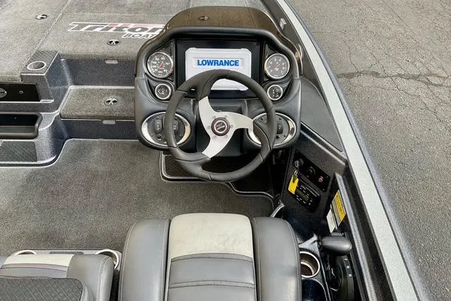 Slide: The Image of 2013 Triton 18XS boat dashboard with Lowrance display and steering wheel. - 26
