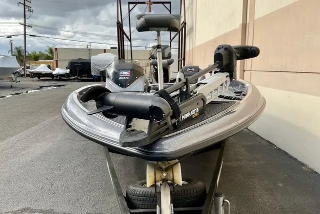 Slide: The Image of 2013 Triton 18XS boat with Minn Kota trolling motor, parked outdoors. - 6