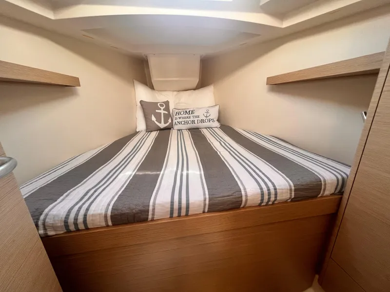Slide: The Image of Cozy cabin interior of 2026 Hanse 348 yacht with striped bedding and nautical-themed pillows. - 14