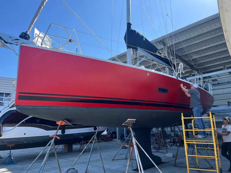 Slide: The Image of Red 2026 Hanse 348 sailboat under maintenance in a boatyard. - 31