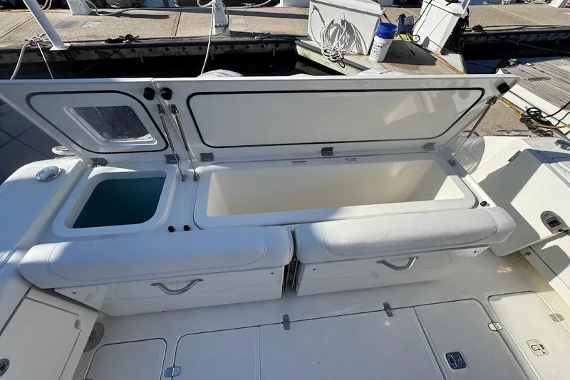 Slide: The Image of 2021 Pursuit OS 385 Offshore boat with open storage compartments at the dock. - 17
