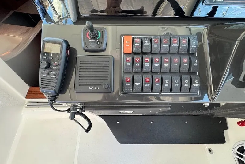 Slide: The Image of Control panel of 2021 Pursuit OS 385 Offshore boat with Garmin radio and switches. - 21