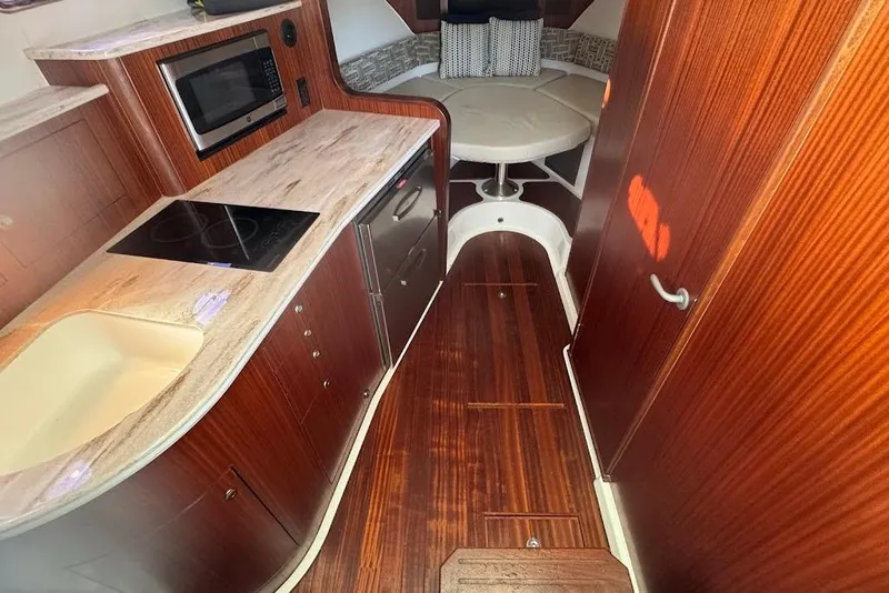 Slide: The Image of 2021 Pursuit OS 385 Offshore interior with kitchen and seating area. - 24