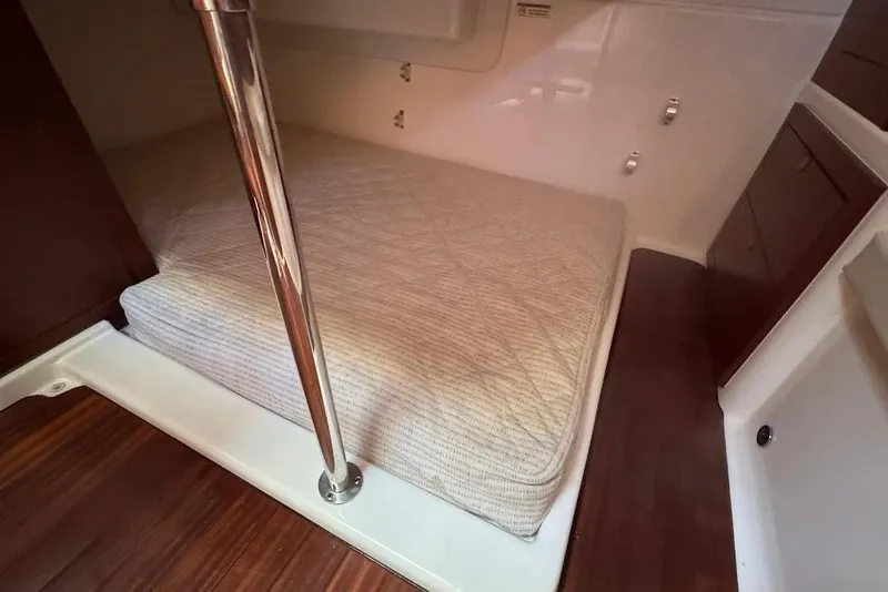 Slide: The Image of 2021 Pursuit OS 385 Offshore cabin interior with bed and wooden accents. - 25
