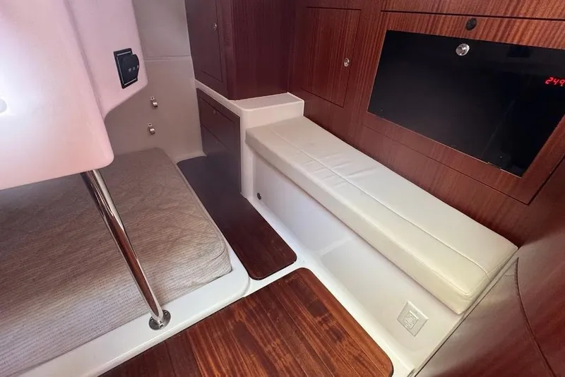 Slide: The Image of 2021 Pursuit OS 385 Offshore cabin interior with wood finish and seating area. - 26