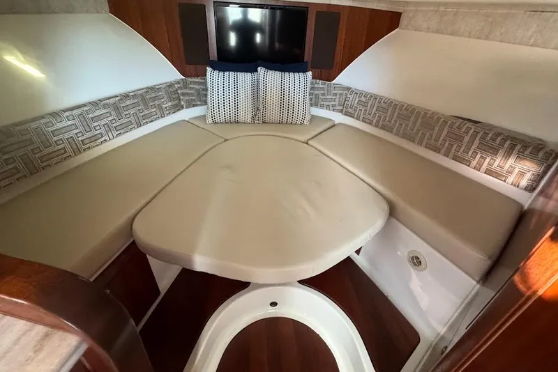 Slide: The Image of 2021 Pursuit OS 385 Offshore cabin interior with cushioned seating and patterned pillows. - 27