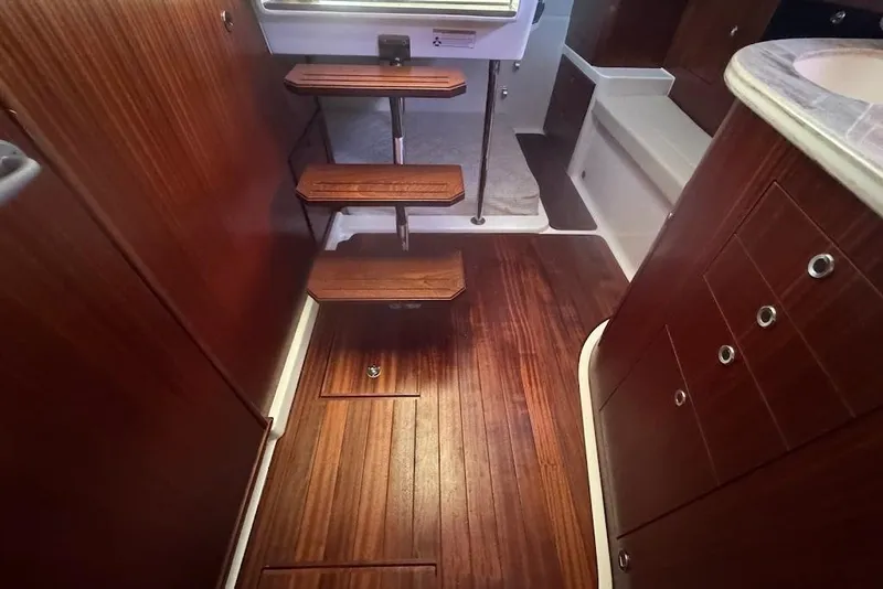 Slide: The Image of 2021 Pursuit OS 385 Offshore interior with wooden flooring and compact staircase. - 28