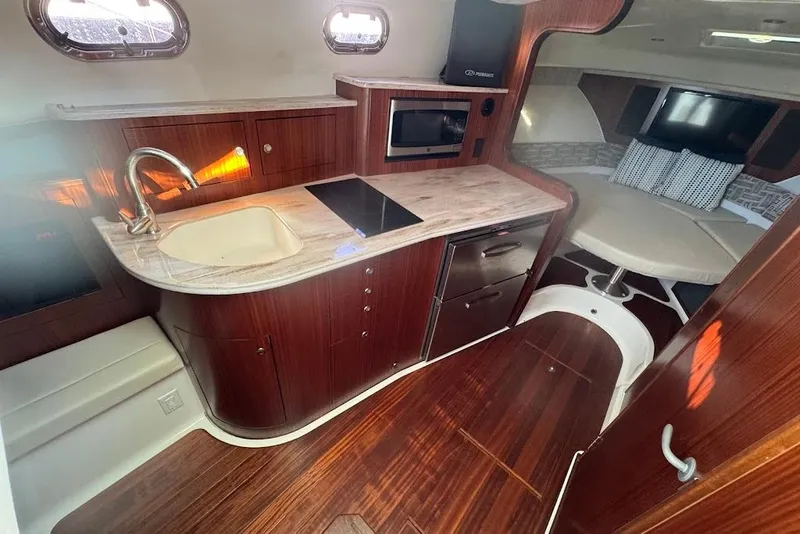 Slide: The Image of 2021 Pursuit OS 385 Offshore interior with kitchenette, sink, and seating area. - 32