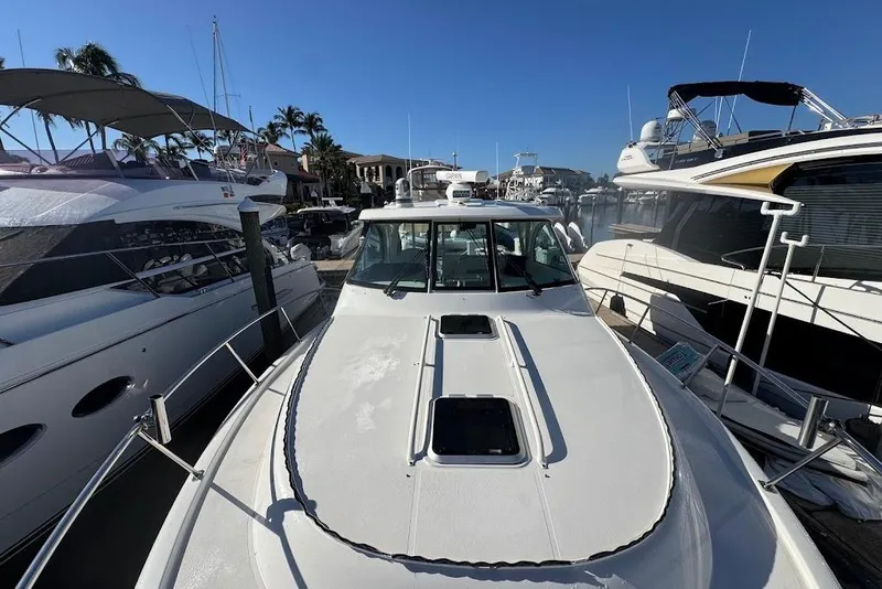 Slide: The Image of 2021 Pursuit OS 385 Offshore boat docked among other yachts in a marina. - 35