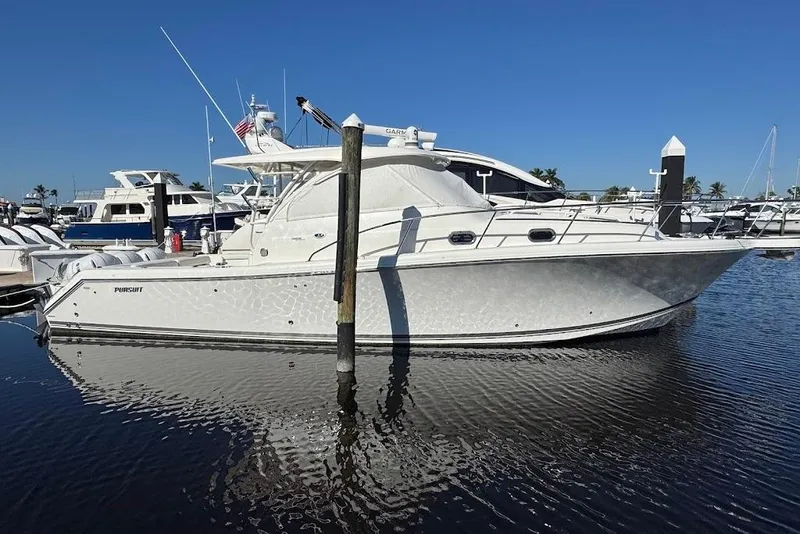 Slide: The Image of 2021 Pursuit OS 385 Offshore boat docked in a marina under clear blue skies. - 38