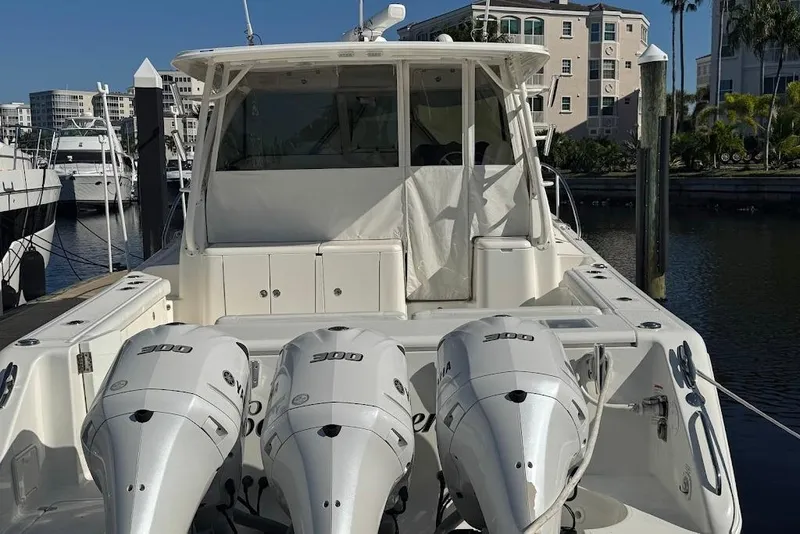 Slide: The Image of 2021 Pursuit OS 385 Offshore boat with triple 300 horsepower engines docked at marina. - 42