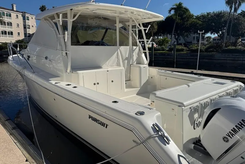 Slide: The Image of 2021 Pursuit OS 385 Offshore boat docked, featuring Yamaha outboard engine. - 43