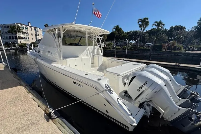 Slide: The Image of 2021 Pursuit OS 385 Offshore boat docked, featuring Yamaha engines and American flag. - 44
