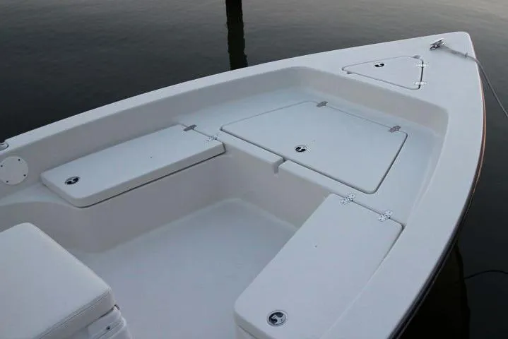 Slide: The Image of Manufacturer Provided Image: 2019 Cobia 21 Bay boat with storage compartments on calm water. - 12