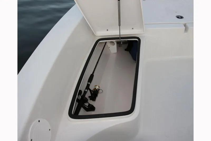Slide: The Image of Manufacturer Provided Image: 2019 Cobia 21 Bay boat storage compartment with fishing rod. - 13