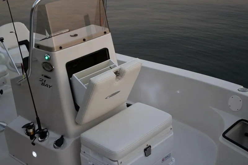 Slide: The Image of Manufacturer Provided Image: 2019 Cobia 21 Bay boat with open storage compartment and cushioned seat. - 14