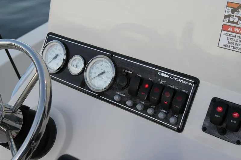 Slide: The Image of Manufacturer Provided Image: Control panel of a 2019 Cobia 21 Bay boat with gauges and switches. - 16