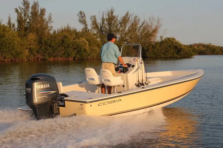 Slide: The Image of Manufacturer Provided Image: 2019 Cobia 21 Bay boat cruising on a calm river with a Yamaha outboard motor. - 4